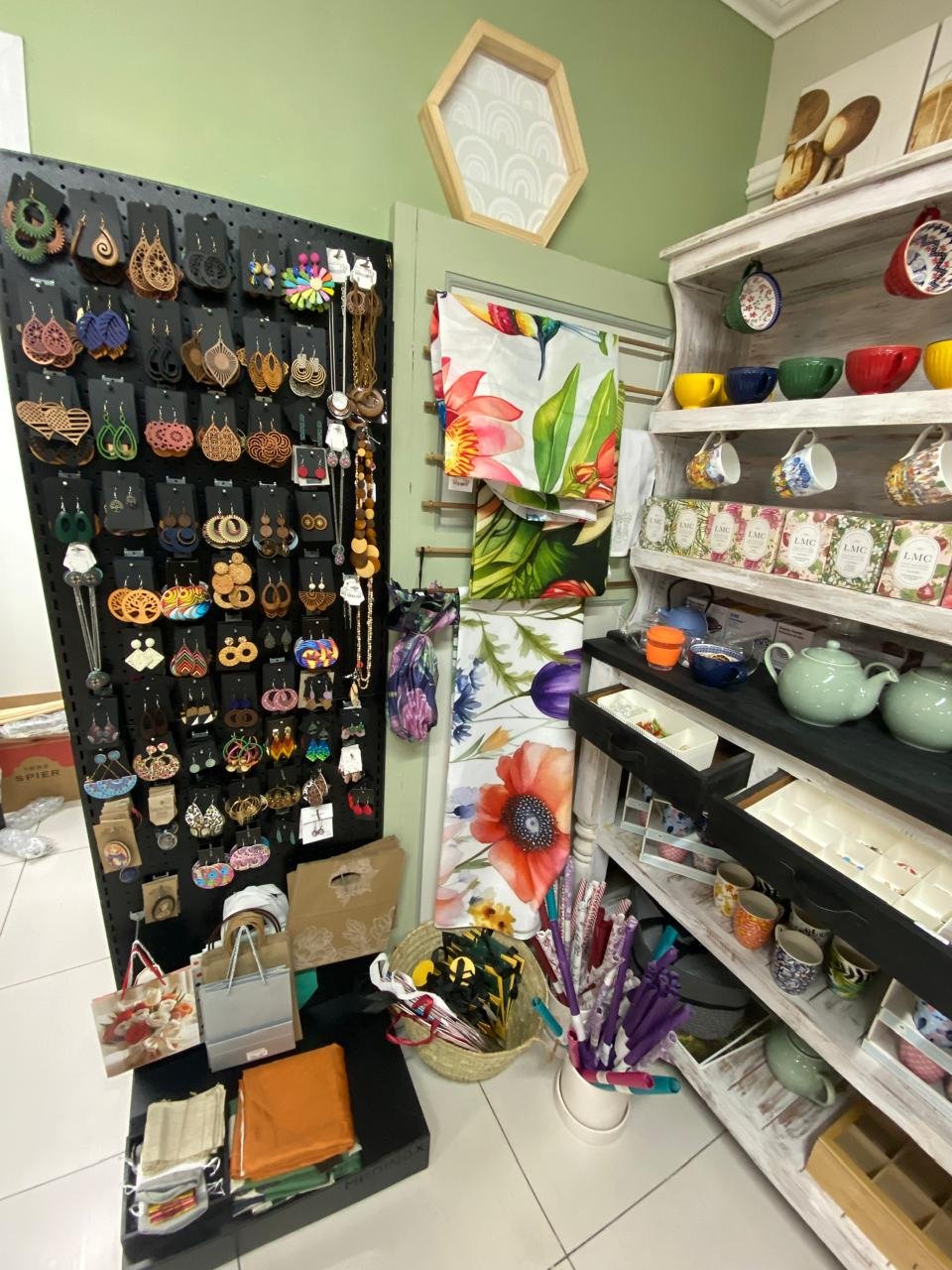 The earring pegboard beside the painted dresser and tea towels