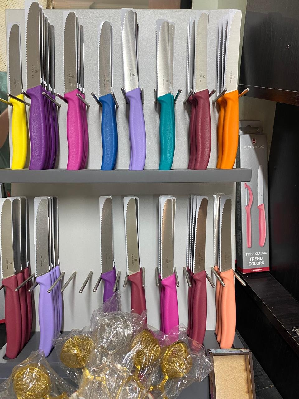 Victorinox Swiss Classic knives in bright handle colours on a rack