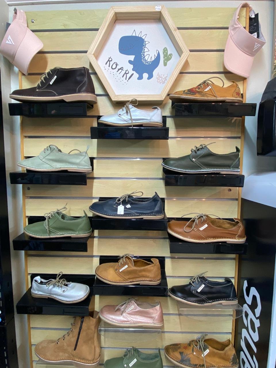 A wall of hand-stitched leather lace-ups in tan, olive, navy and metallic