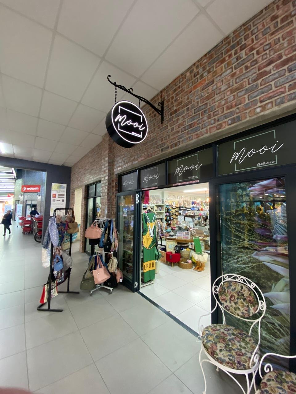 The round neon Mooi sign hanging in the walkway of the Spar Centre