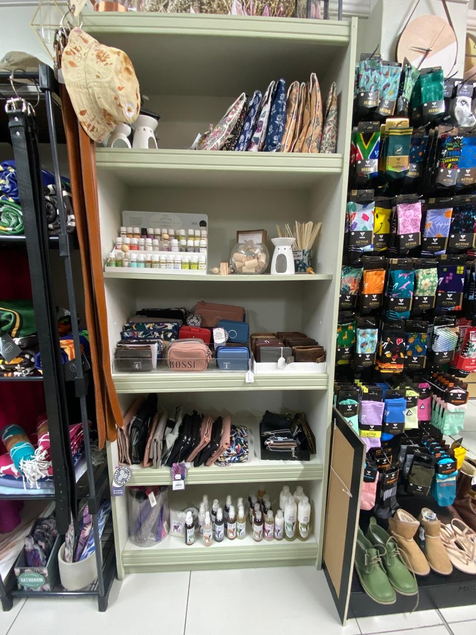 A shelf of wallets and purses beside the wall of Versus socks